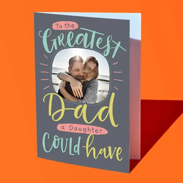 A personalised Fathers Day card reading To the greatest Dad a daughter could have, featuring a circular photo and colourful lettering on a grey background.